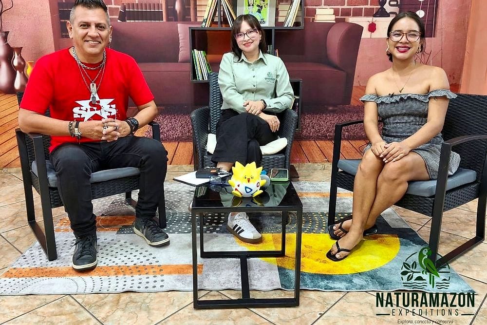Tres personas sentadas en el set de un programa de televisión durante una entrevista
